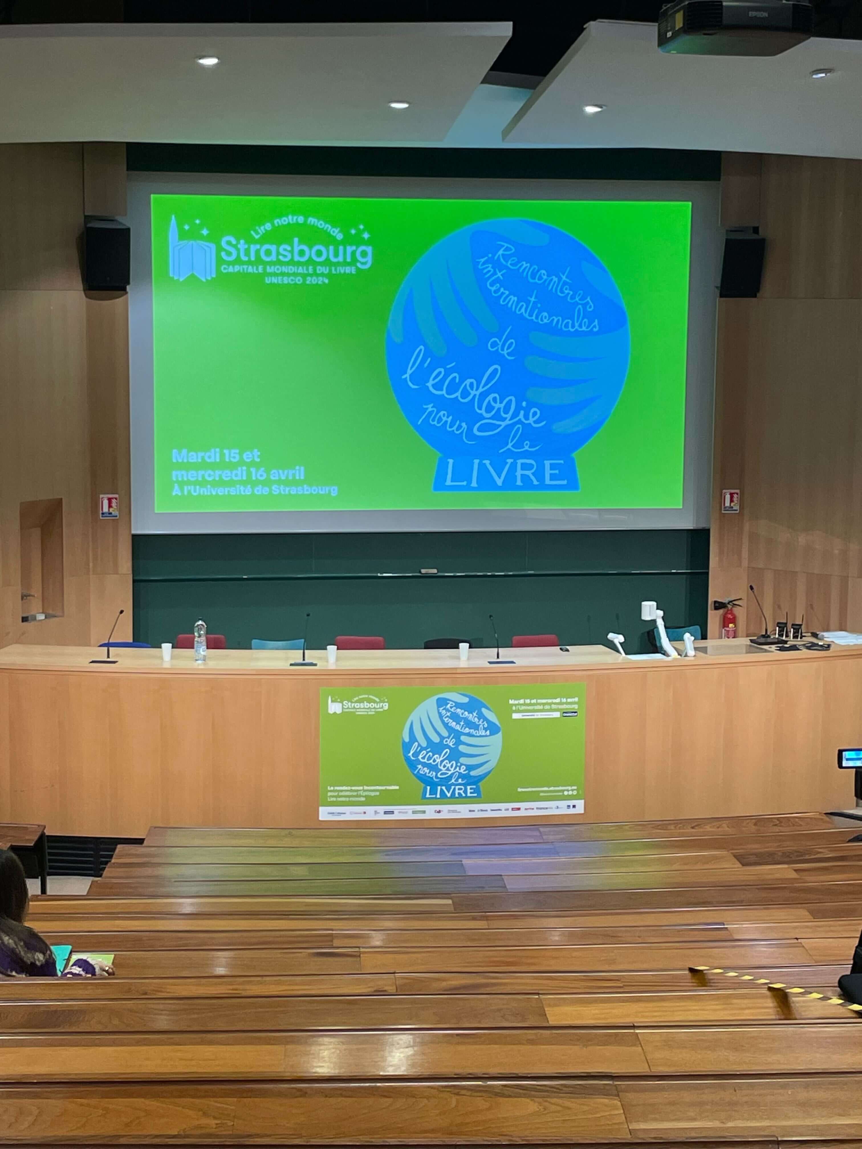 Logo of the conference projected on a screen in a conference hall.