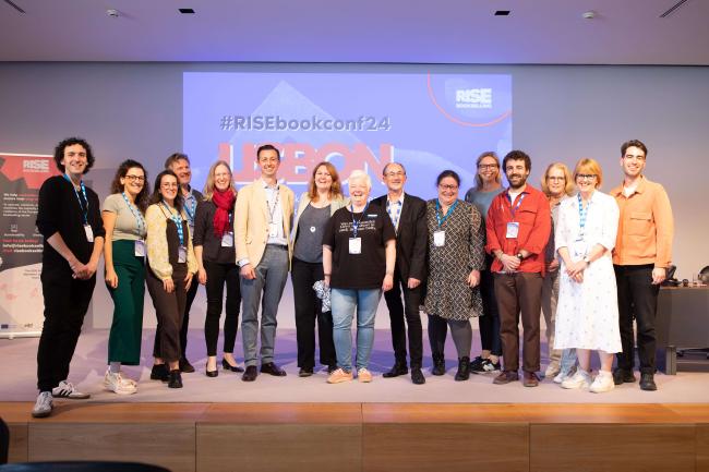 The EIBF team and board members posing in front of a screen.