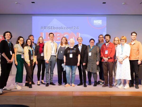 The EIBF team and board members posing in front of a screen.